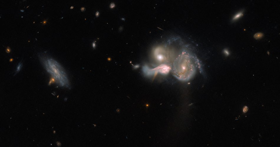 Tre galassie sembrano fondersi a destra; mentre una galassia a spirale sconnessa dalle altre e più debole si trova a sinistra. Nello sfondo, invece, si vedono varie galassie più piccole e deboli, e un paio di stelle.